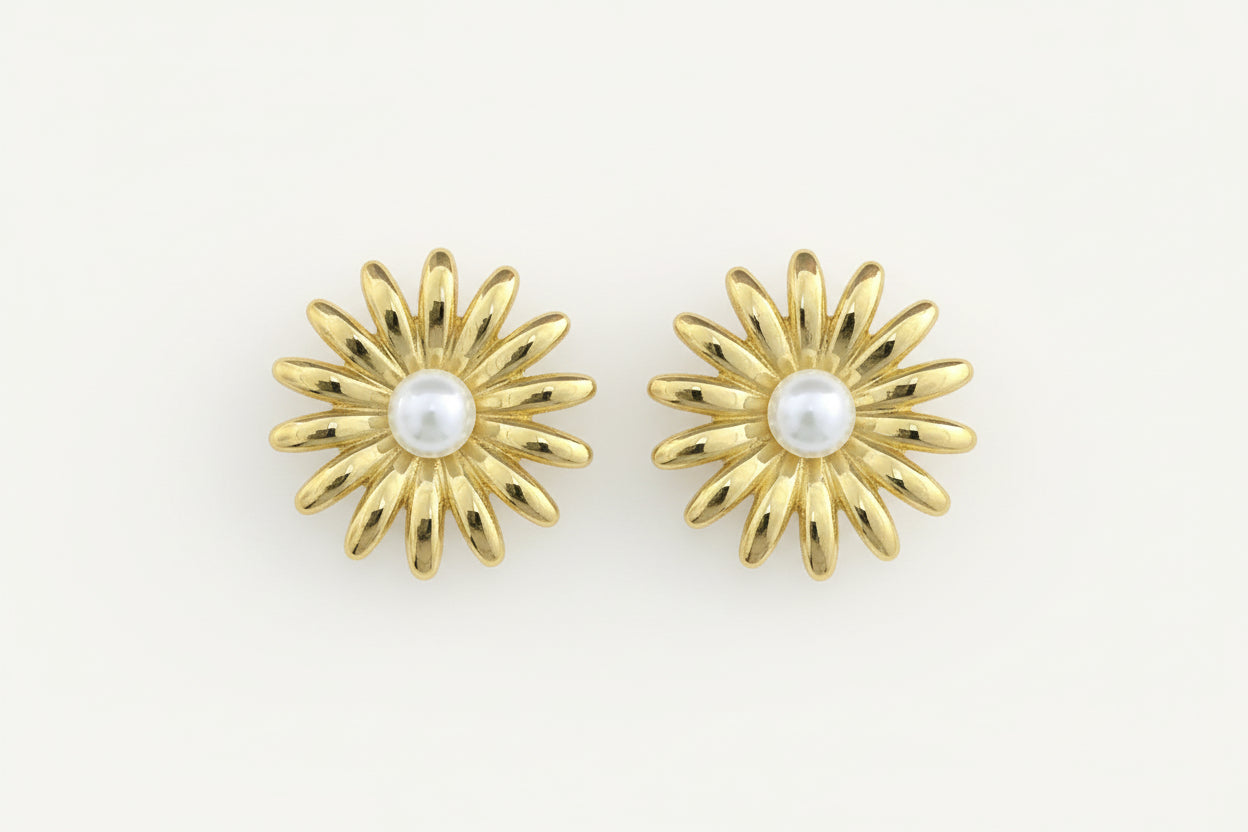 Gold earrings with pearl centers on a white background