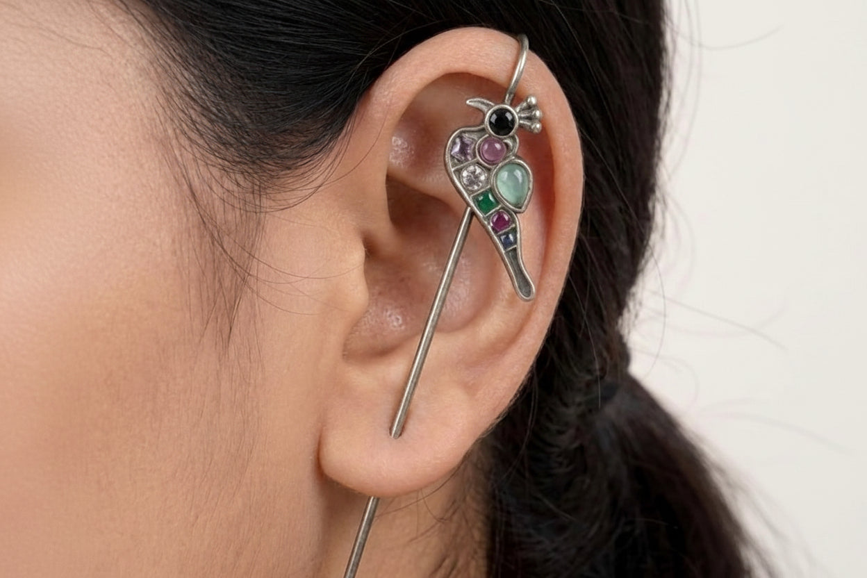 Close-up of an ear with a decorative earring featuring gemstones.