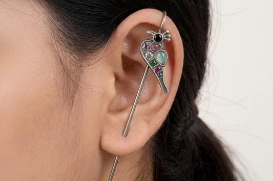 Close-up of an ear with a decorative earring featuring gemstones.