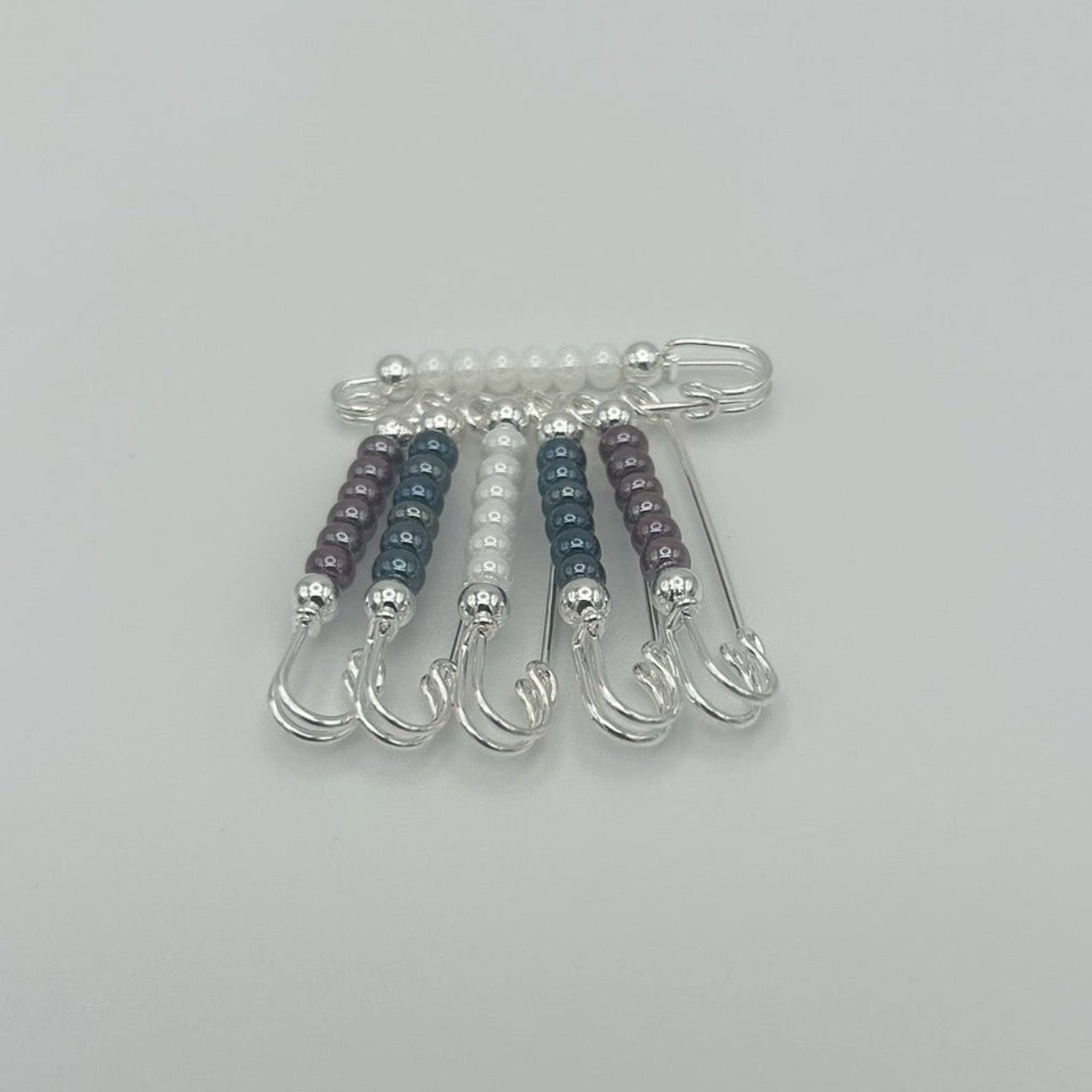 Set of safty pins on a light gray background