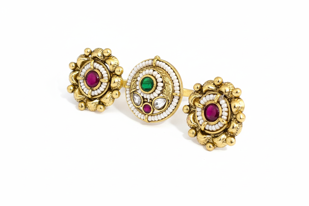 Gold double finger ring with gemstones on a white background