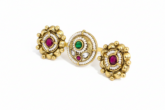 Gold double finger ring with gemstones on a white background