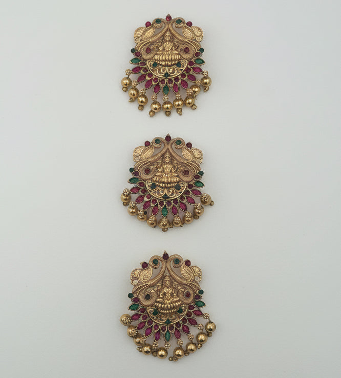 Three ornate gold hairpins or brooch with gemstones on a white background