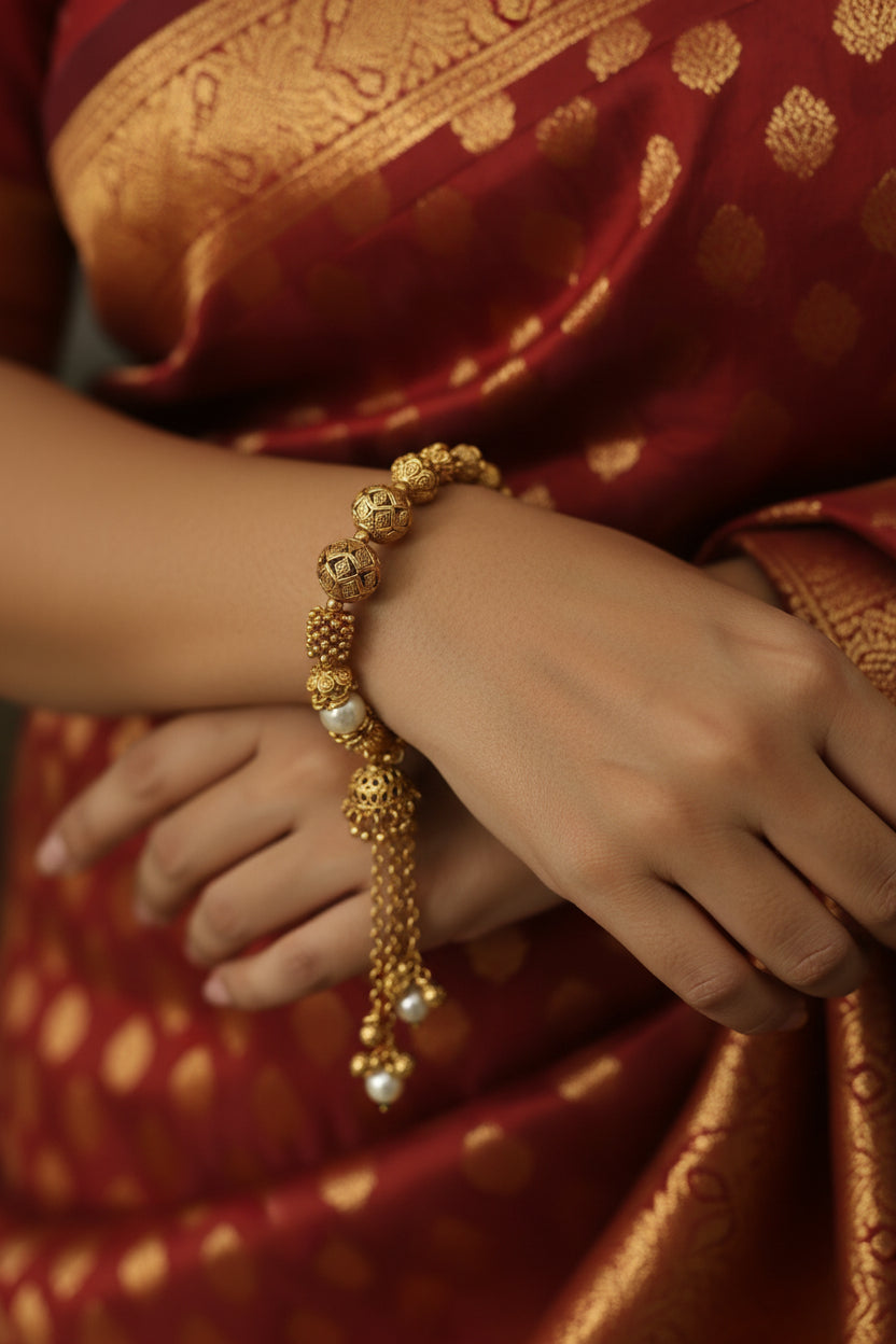 antique Gold plated and pearl bracelet on a mannequin against a white background