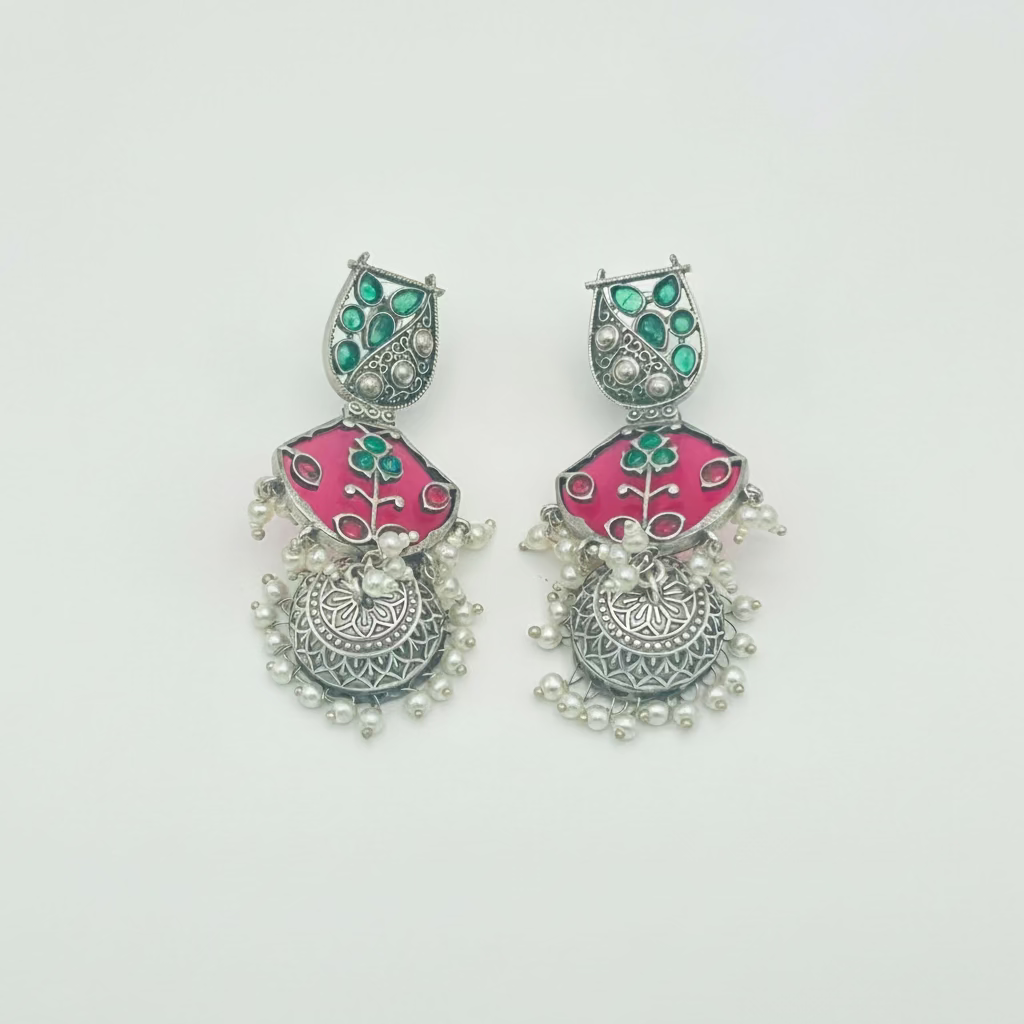 Pair of earrings with pink and green design on a white background