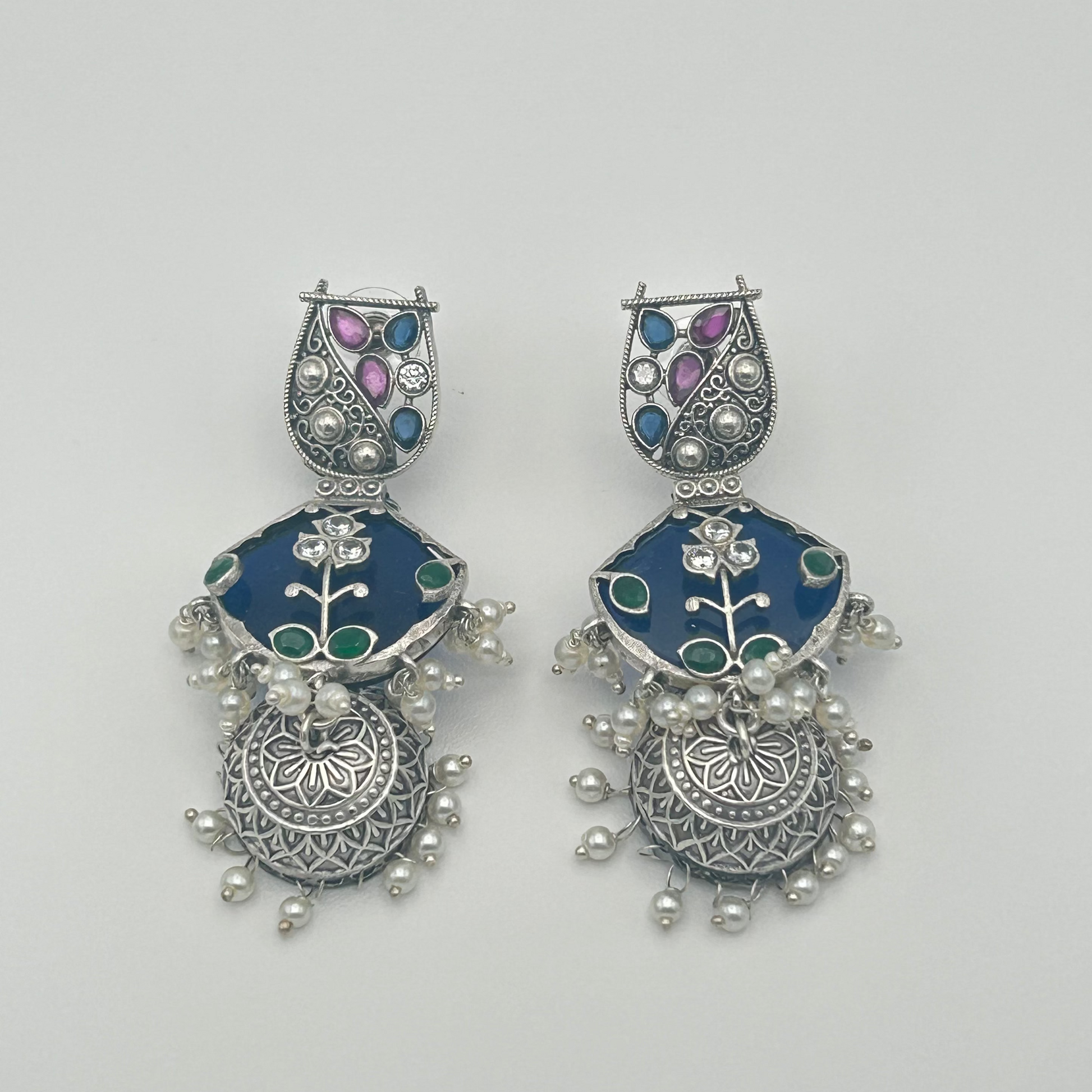 Pair of silver earrings with blue and purple stones on a white background