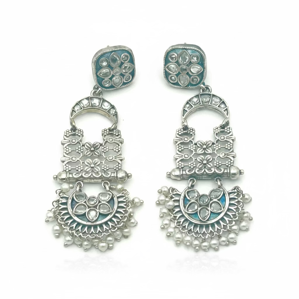 Pair of silver earrings with intricate designs on a white background