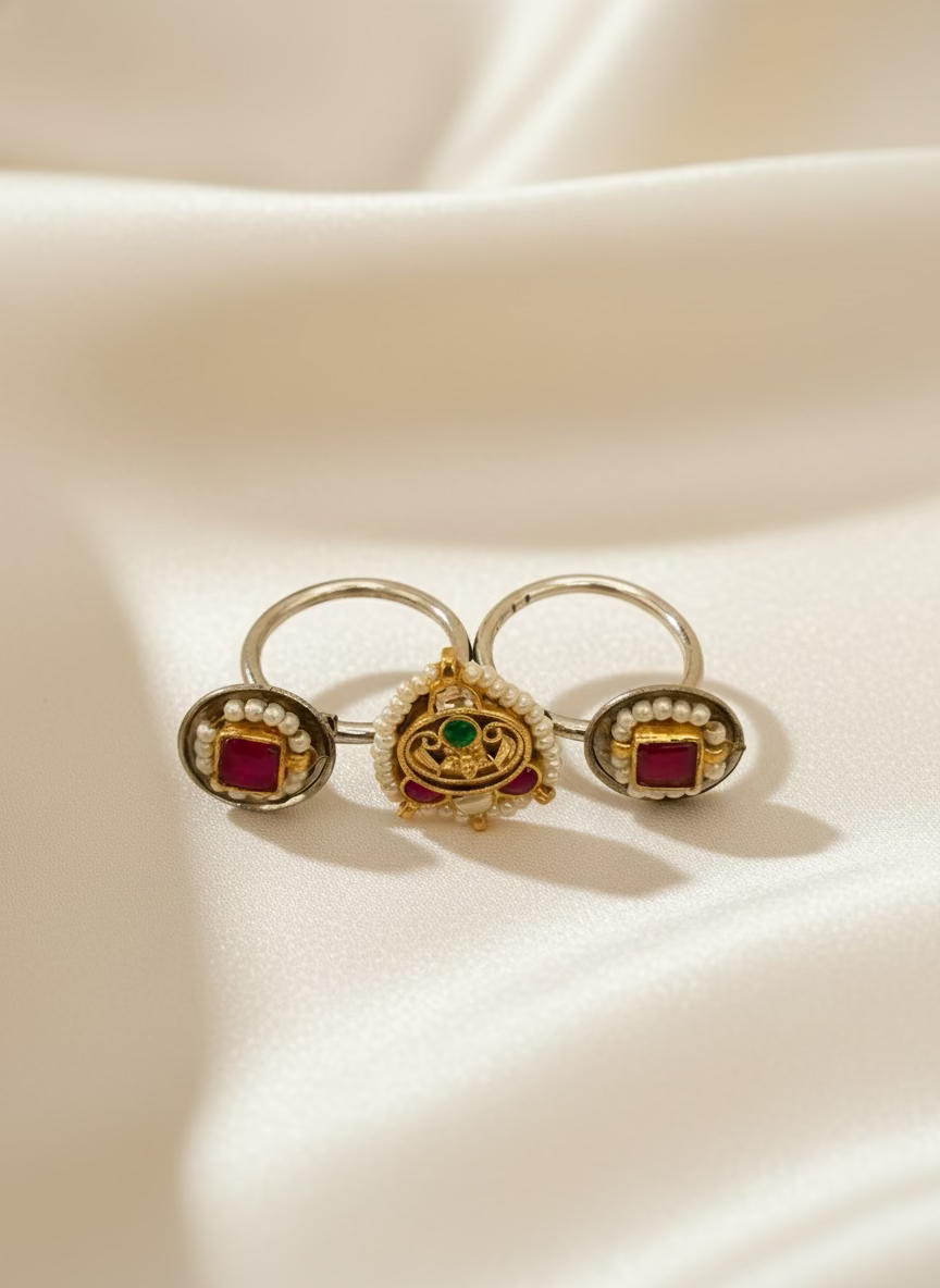 Pair of earrings with gemstones and pearls on a light gray background