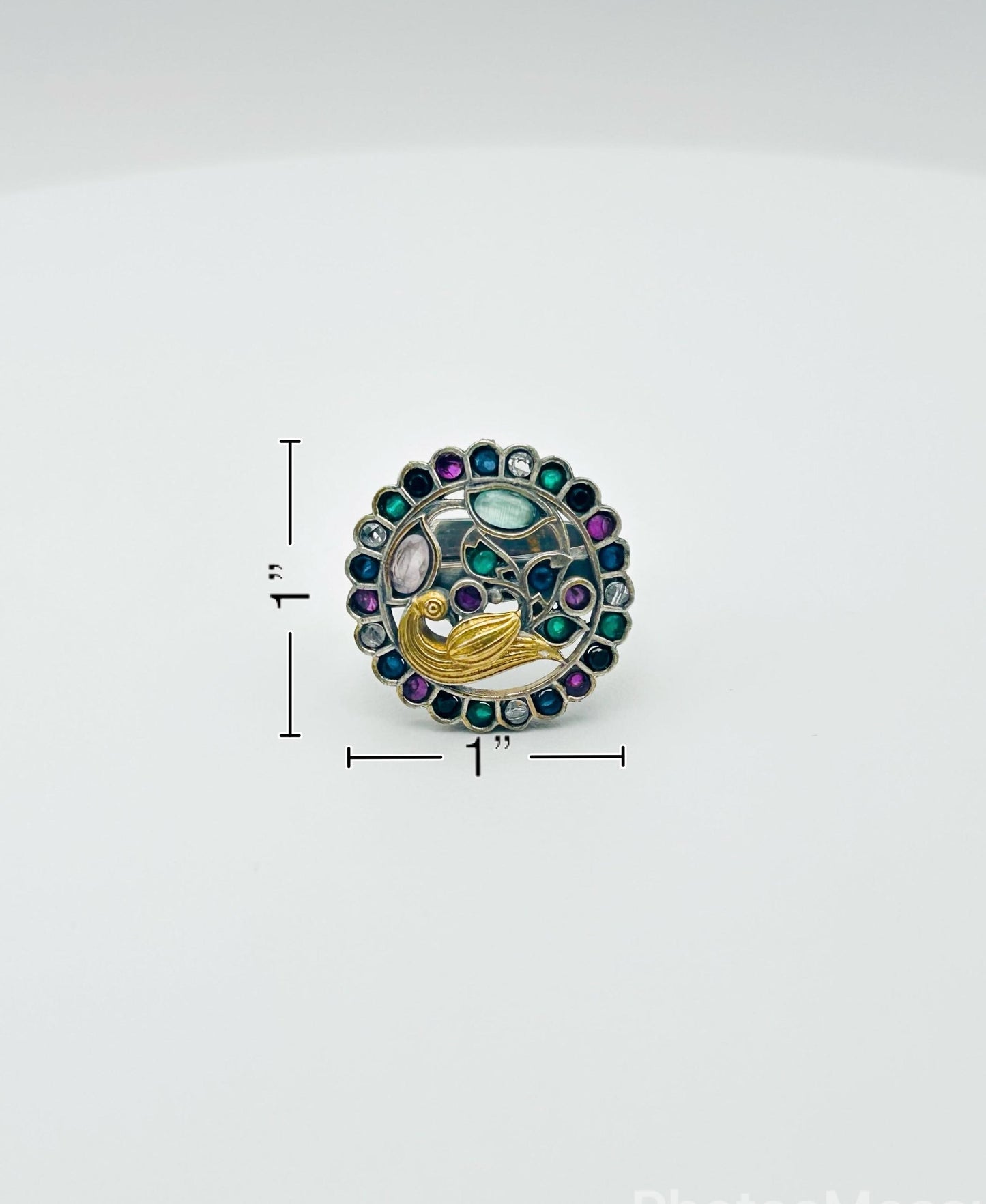 Decorative brooch with colorful gemstones on a white background