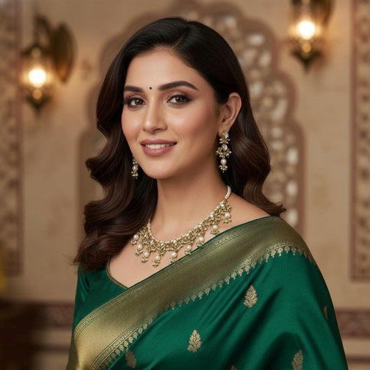 Woman wearing a green saree with gold details indoors