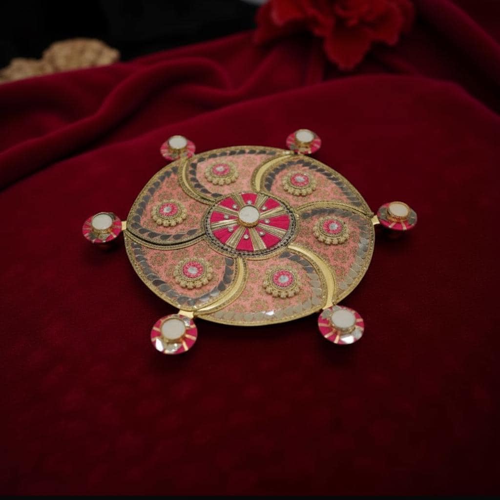 Decorative rangoli with intricate design on a red fabric background