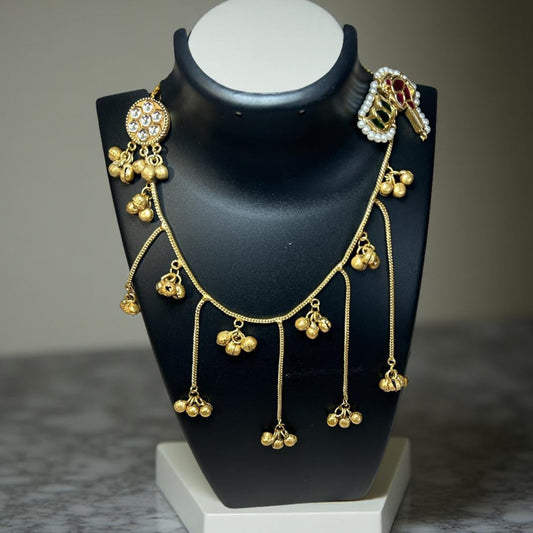 Gold earning with hanging pendants on a black mannequin bust against a neutral background