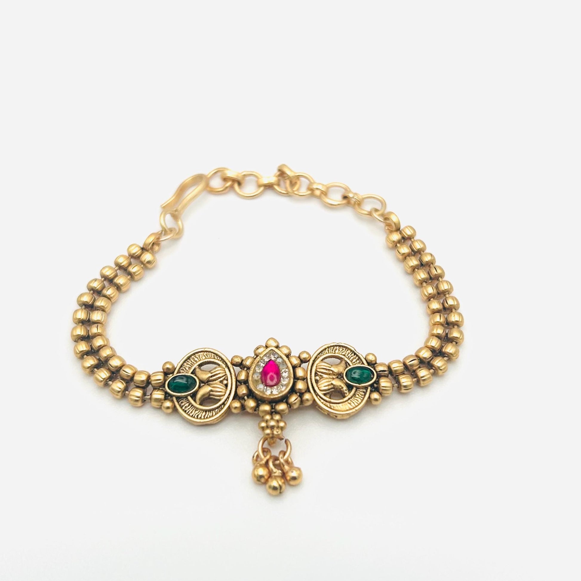 Gold bracelet with gemstones on a white background