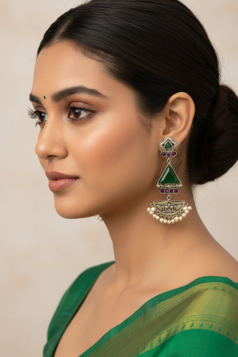 Woman wearing green earrings with a neutral background