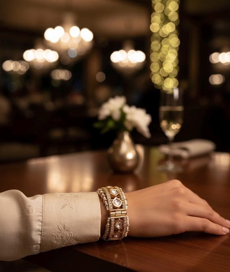 Hand with a bracelet on a table in a dimly lit restaurant setting